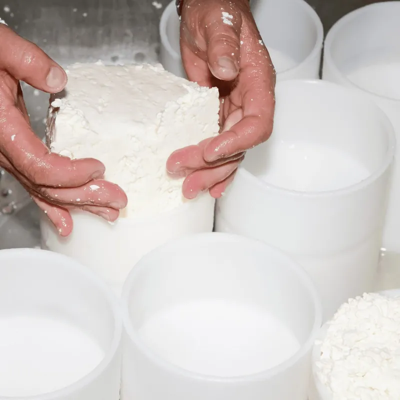 Verse kaas wordt met de hand in vorm gebracht